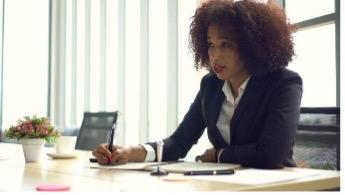 woman sitting at desk listening to someone else speak