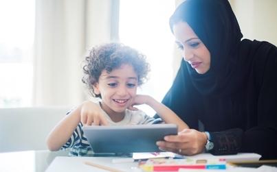 Mother helping daughter with a tablet