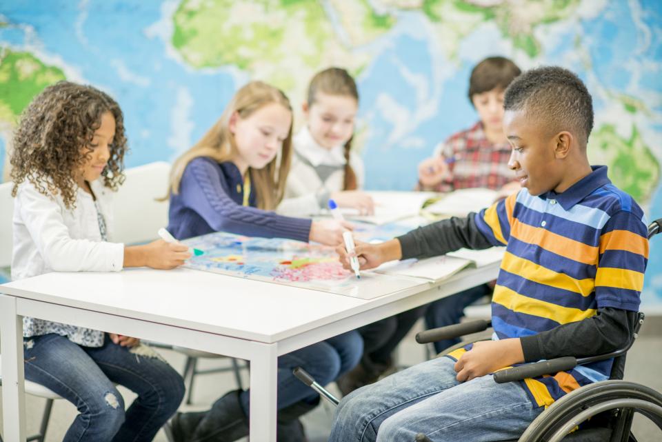 Elementary boy in wheelchair participates in group learning